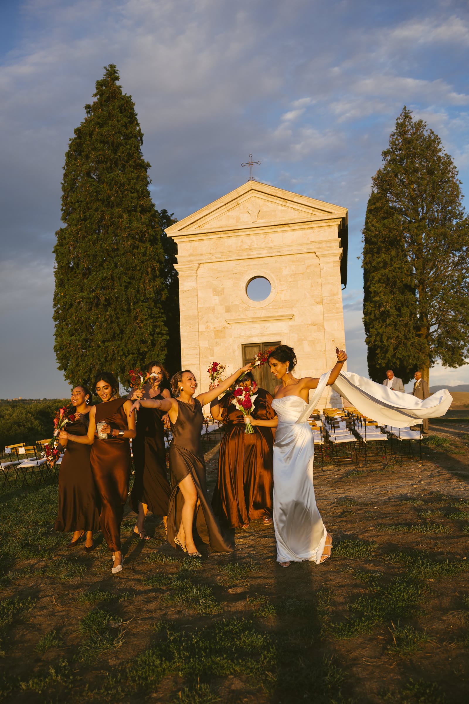 Gli sposi e gli invitati davanti alla cappella al tramonto
