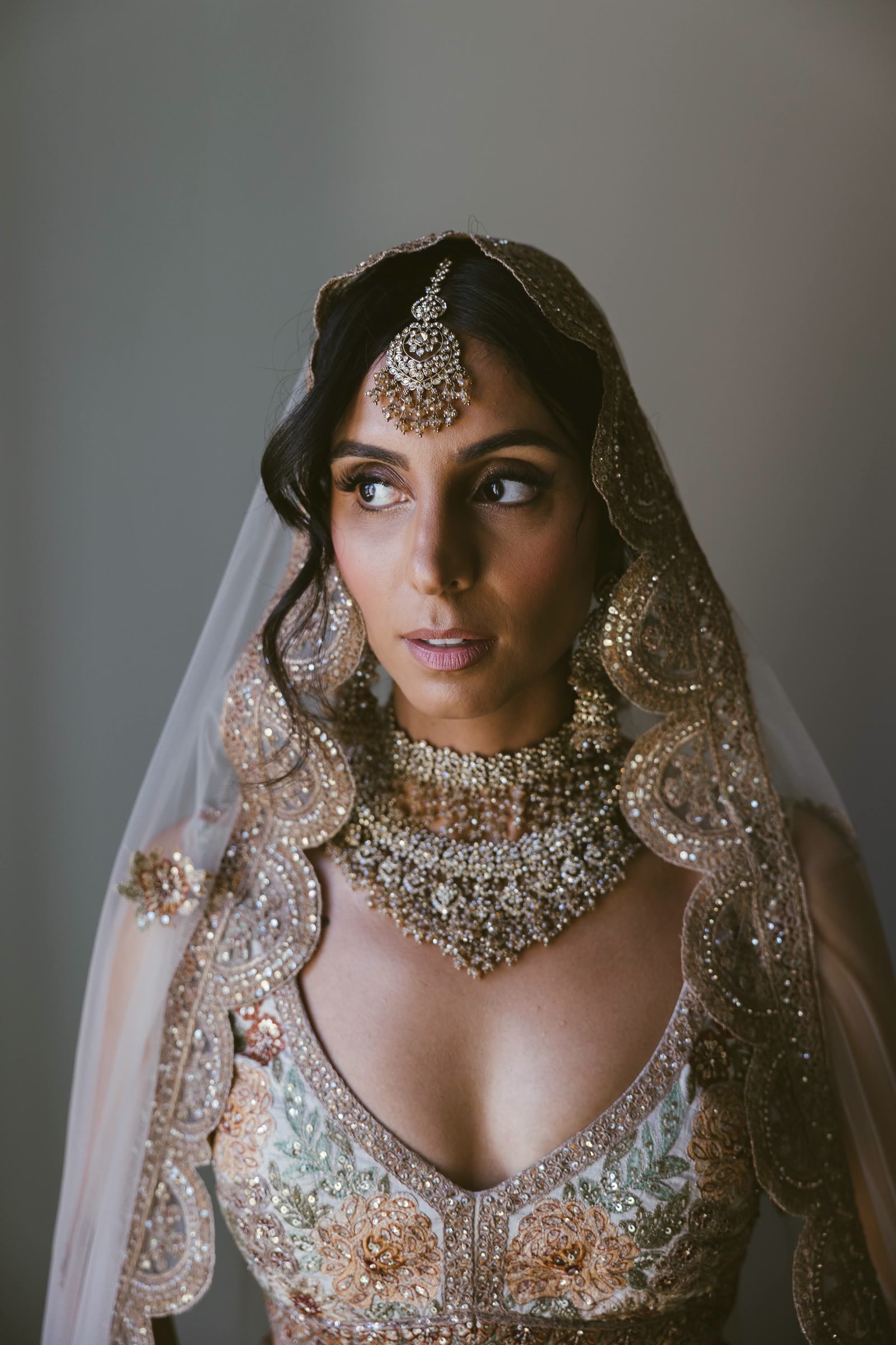 La sposa, gioielli e velo, con lo sguardo altrove
