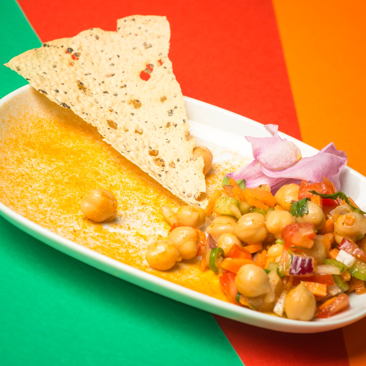 Chaat di ceci con un papadam su un piatto bianco