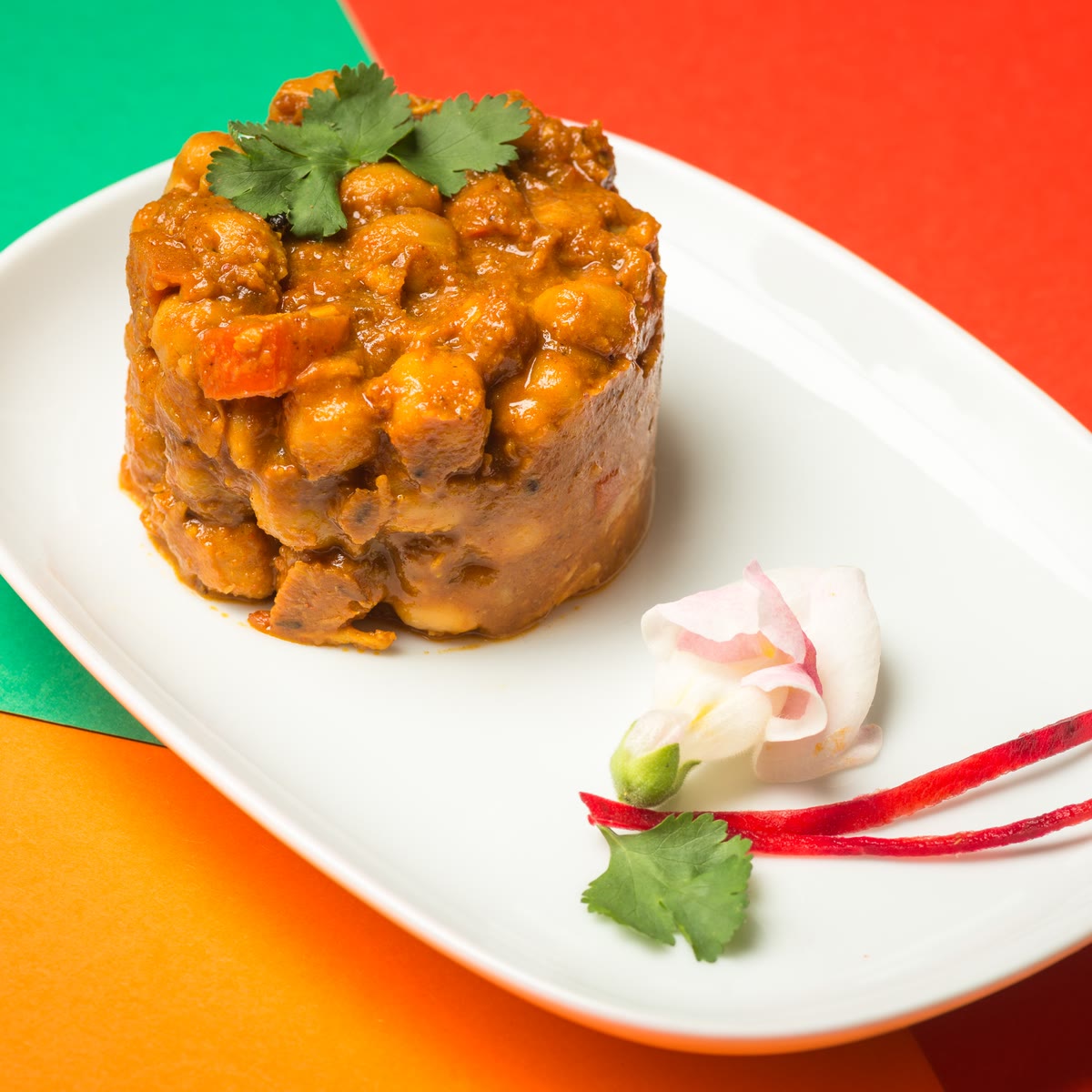 Chana masala con coriandolo e un fiore di carota