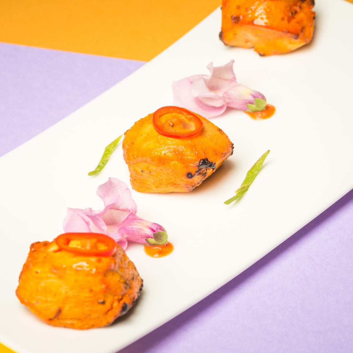 Cubi di chilli paneer con una fetta di peperoncino rosso
