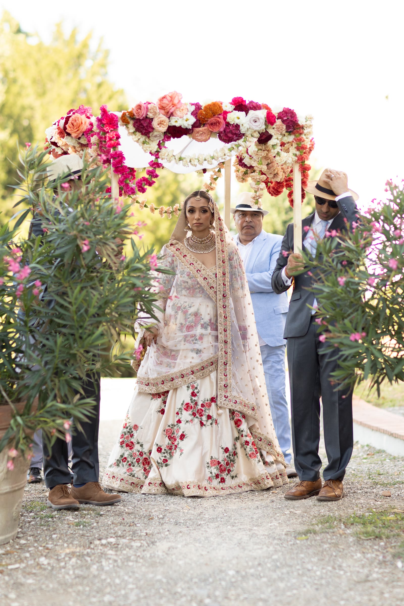 La sposa sotto un arco di fiori, gli invitati intorno